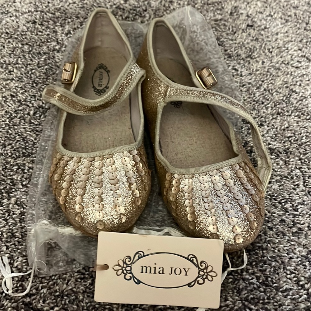 A pair of Mia Joy shoes. Size youth 3 with a shiny gold color